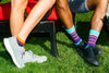 two people showing off their colorful socks