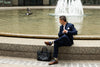 a man sitting by a fountain wearing designer socks