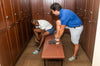 two people in a locker room putting socks on